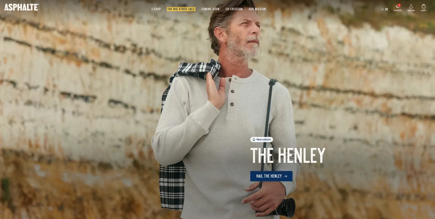 Man holding a plaid bag with 'The Henley' text on a textured background
